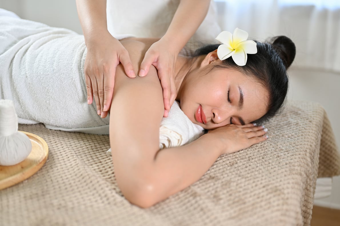 Attractive woman lying on spa massage table, getting body massag